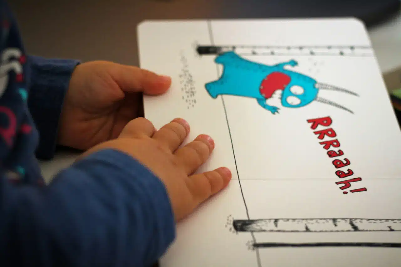 Small hands holding a book for children