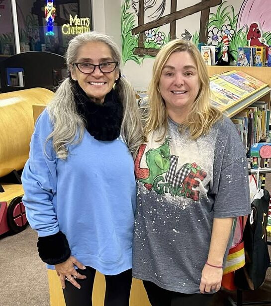 Photo shows Constance Willis and Rhonda Kendziorski standing in the library.