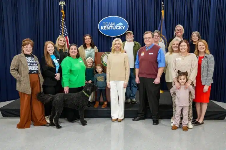 Image shows a crowd of people in a press conference room