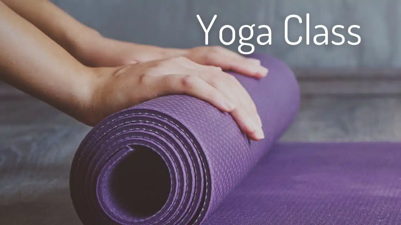Image shows hands rolling up a purple yoga mat. Text says Yoga Class.